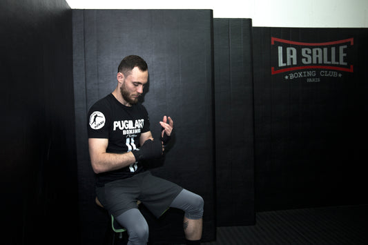 boxeur portant un t-shirt PUGILART de profil en mettant ses bandages